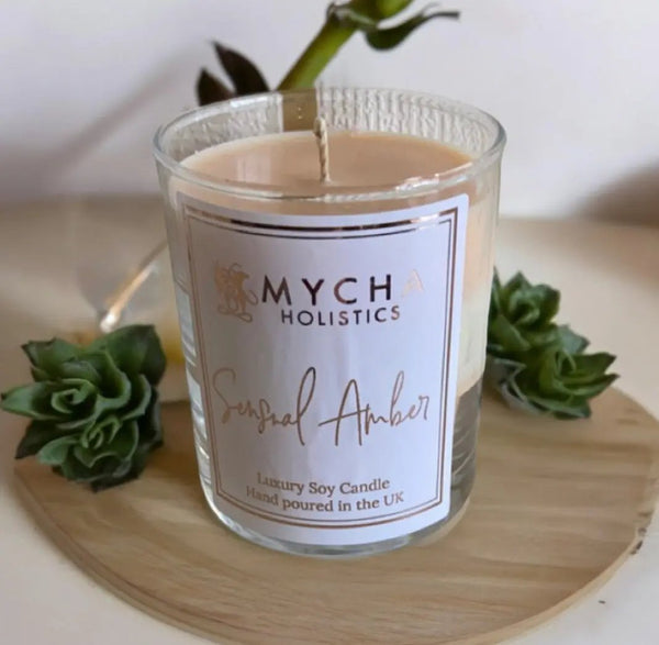 Sensual Amber soy candle in glass jar with amber scent and elegant label on wooden tray with green succulents