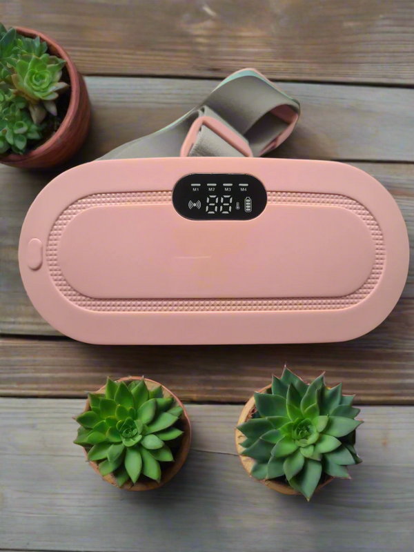 Pink Serene Relief Heating Pad with digital control panel on wooden surface beside two small green succulents for menstrual pain relief