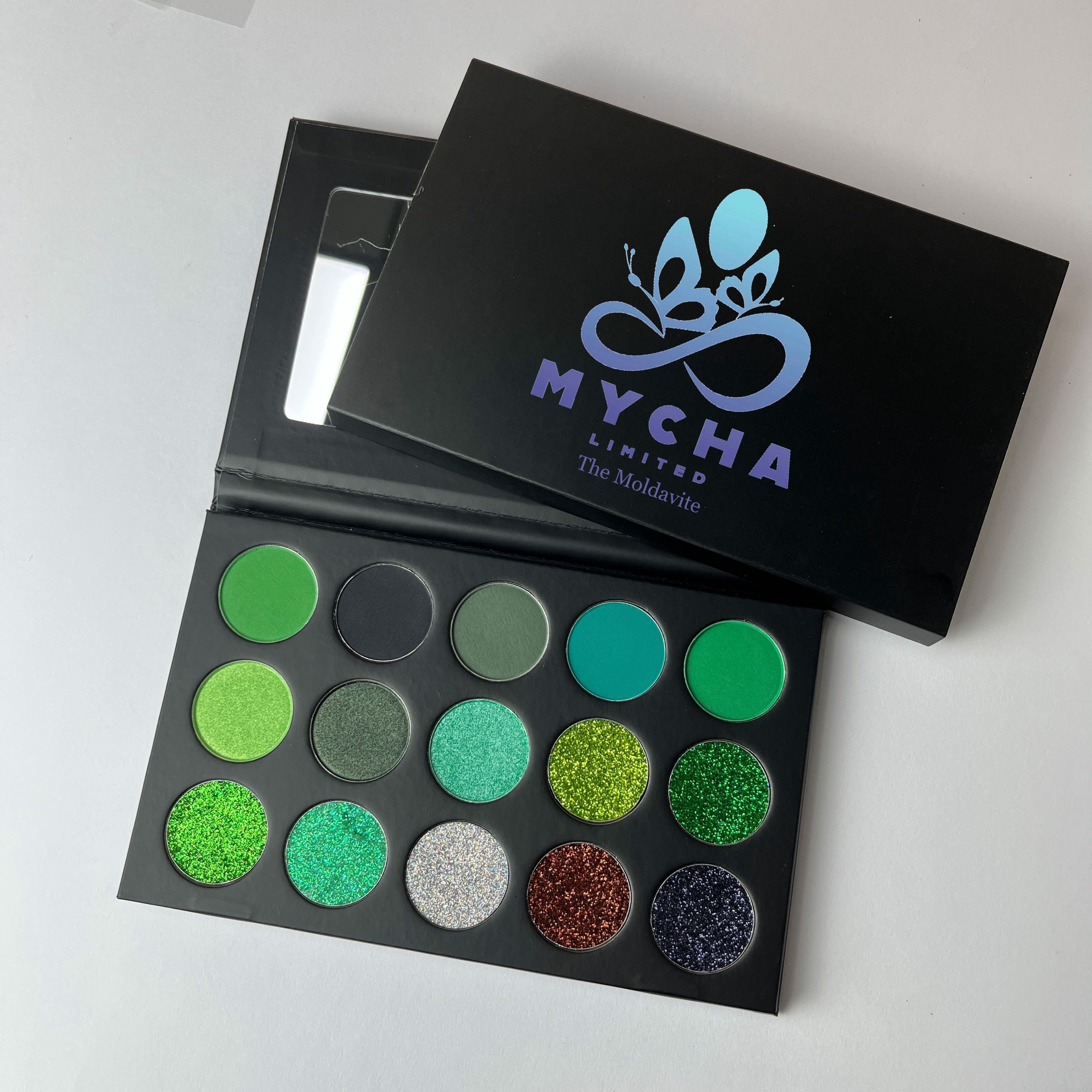 The Moldavite eyeshadow palette with vibrant green shades and shimmering finishes in a sleek black case