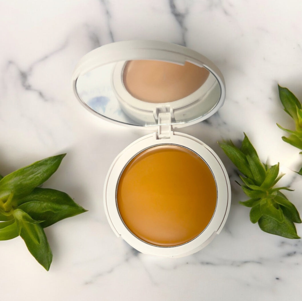 Flawless Blend 2-in-1 foundation and concealer compact with mirror on marble surface with green leaves, GlowUp CC Cream alternative