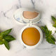Flawless Blend 2-in-1 foundation and concealer compact with mirror on marble surface with green leaves, GlowUp CC Cream alternative