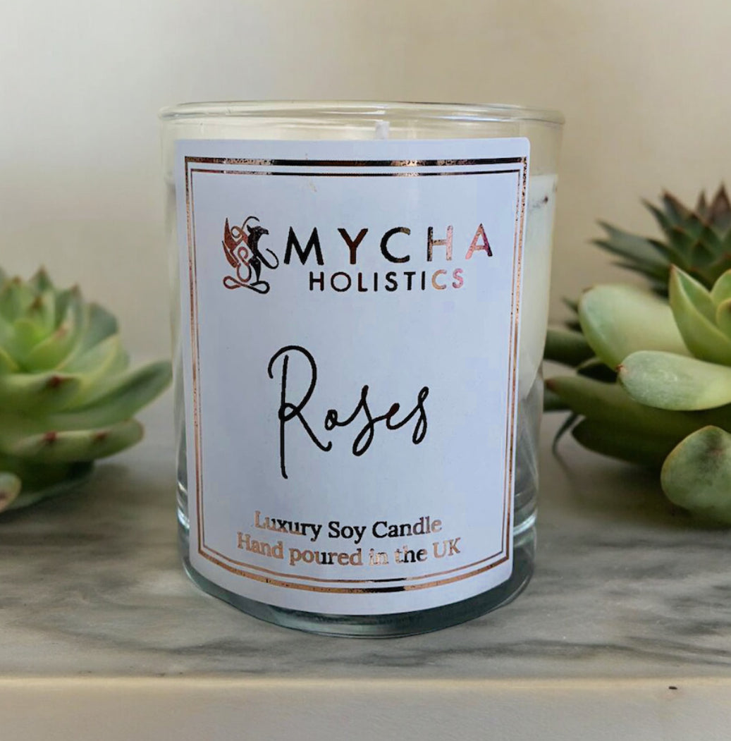 Luxury handmade soy wax Roses Candle by MychaLimited in clear glass jar surrounded by green succulents