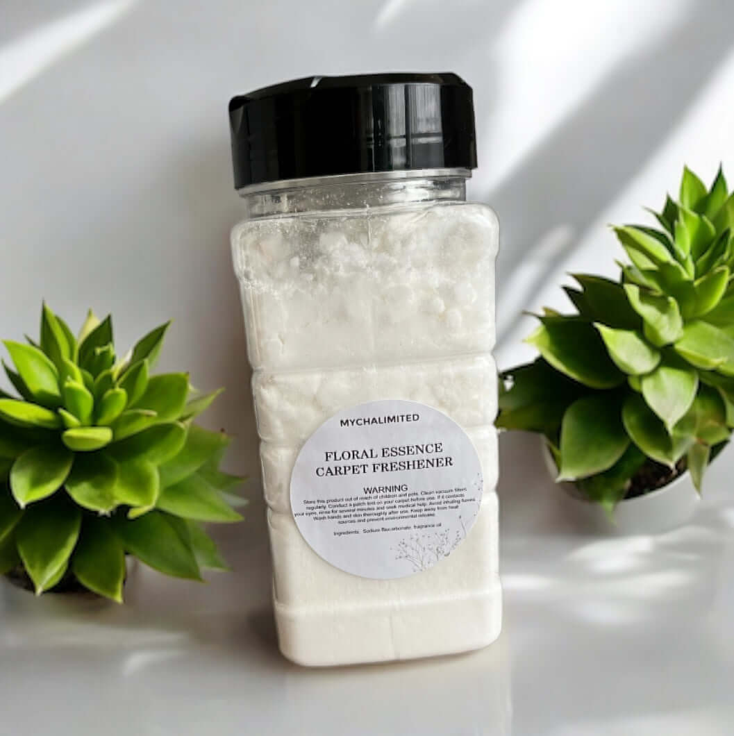 Floral Essence Carpet Freshener bottle with white powder surrounded by green plants on white surface