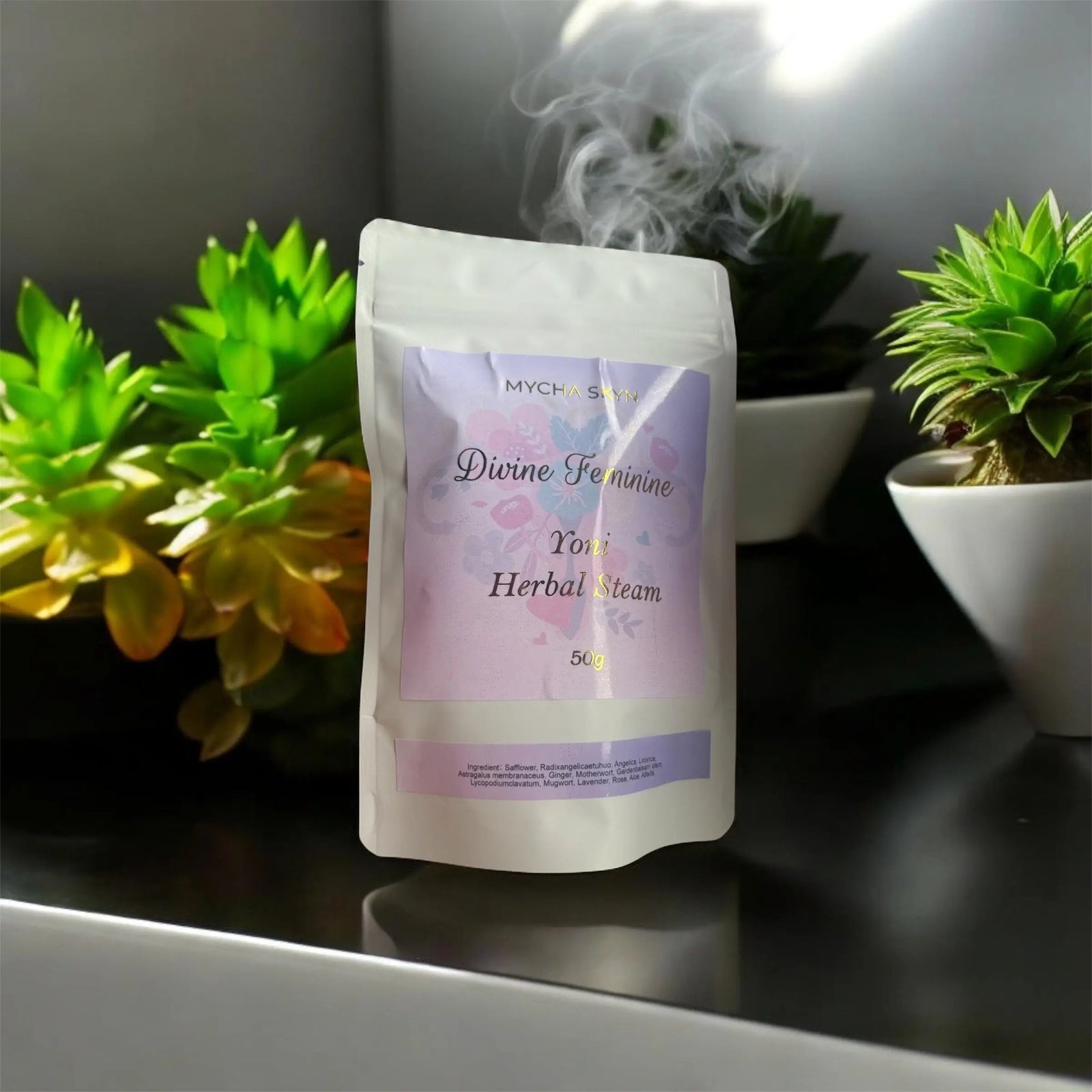 Divine Feminine Herbal Yoni Steam pouch releasing steam surrounded by green succulents on a dark surface