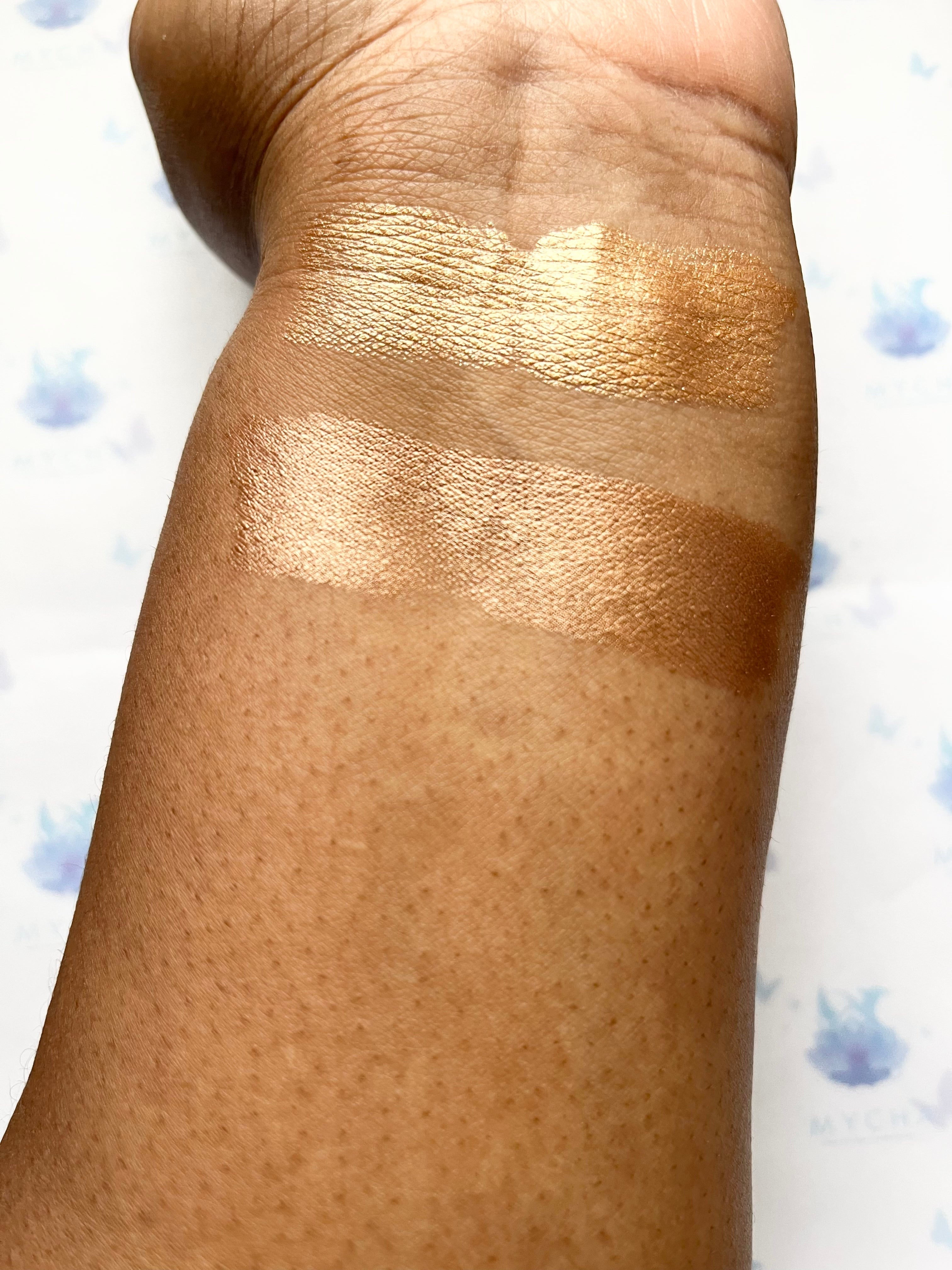 Swatches of Radiant Aura Highlighter Stick showing luminous, velvety golden shimmer on medium skin tone